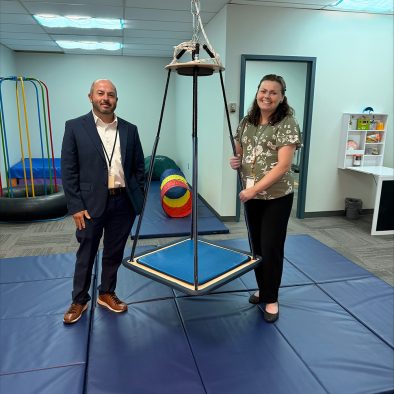 Occupational therapy staff stand near rehabilitation equipment